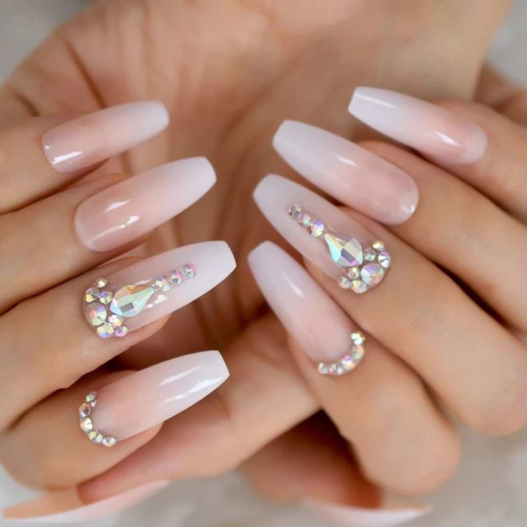 Polish Application nails featuring a soft ombré effect in nude and white tones, elegantly enhanced with intricate rhinestone embellishments for a sophisticated and glamorous look. Polish Application Nail services done at Casa D'Blanca Nails + Spa in Grimsby on the lake.