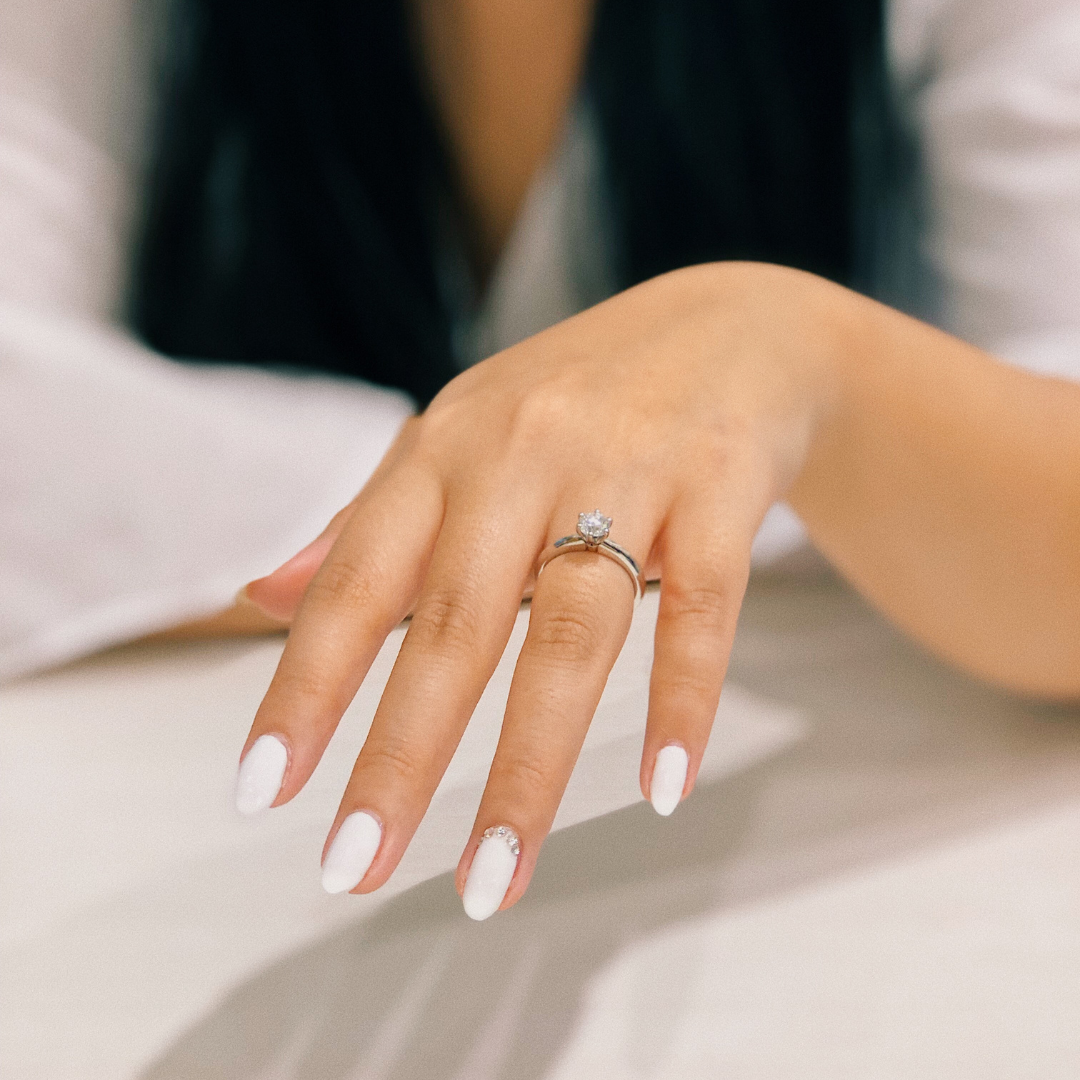 Elegant bridal nail polish application featuring a classic white finish with a delicate rhinestone accent, perfect for special occasions and maintaining nail health. Available at Casa D'Blanca Nails + Spa in Grimsby on the lake.