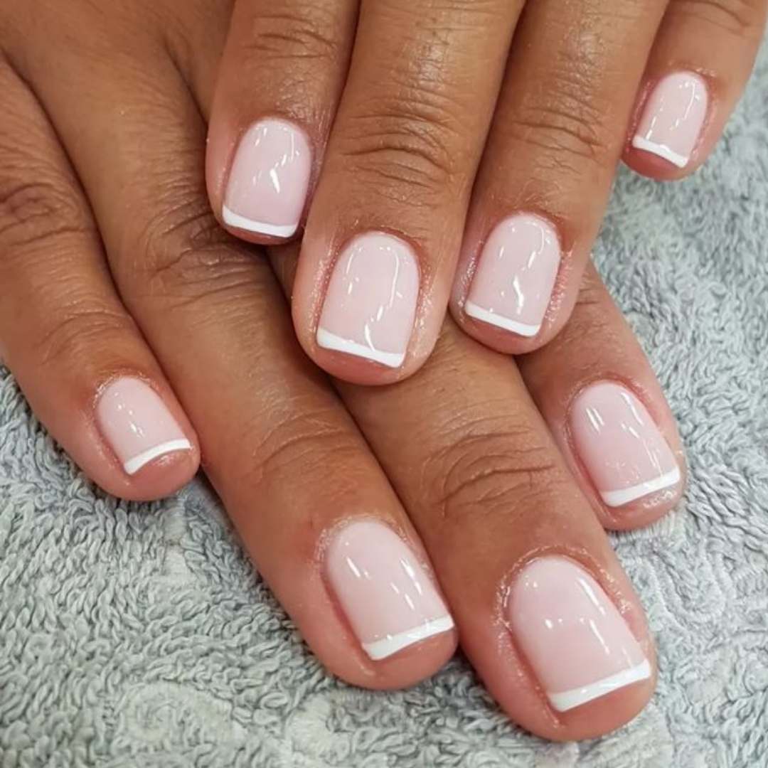 Polish application featuring a timeless French manicure design with soft pink nails and crisp white tips, offering a clean and elegant look. Polish Application Nails done at Casa D'Blanca Nails + Spa in Grimsby on the Lake.