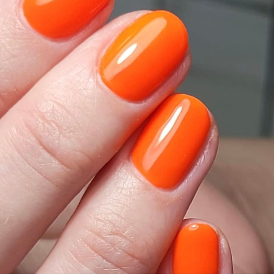 Bright orange soft gel BIAB manicure with a natural rounded shape, part of our manicure services in Grimsby.