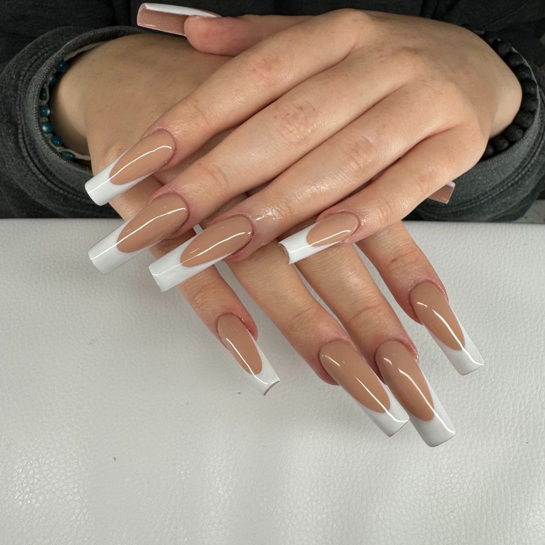 Long coffin-shaped nail enhancements with nude base and white French tips, created at our nail salon in Grimsby.