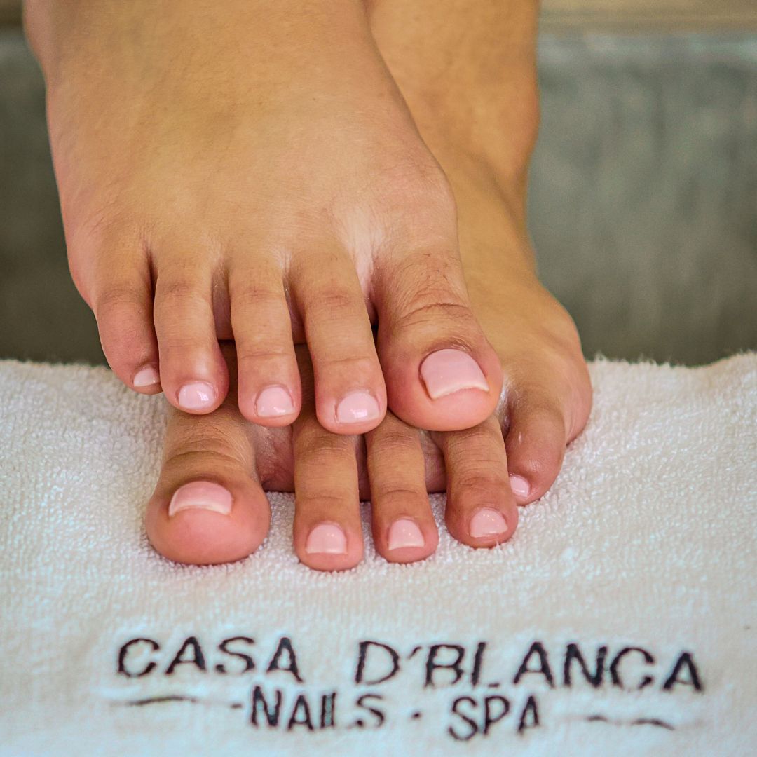 Natural pedicure with nude polish performed at Casa D’Blanca Nail Spa.