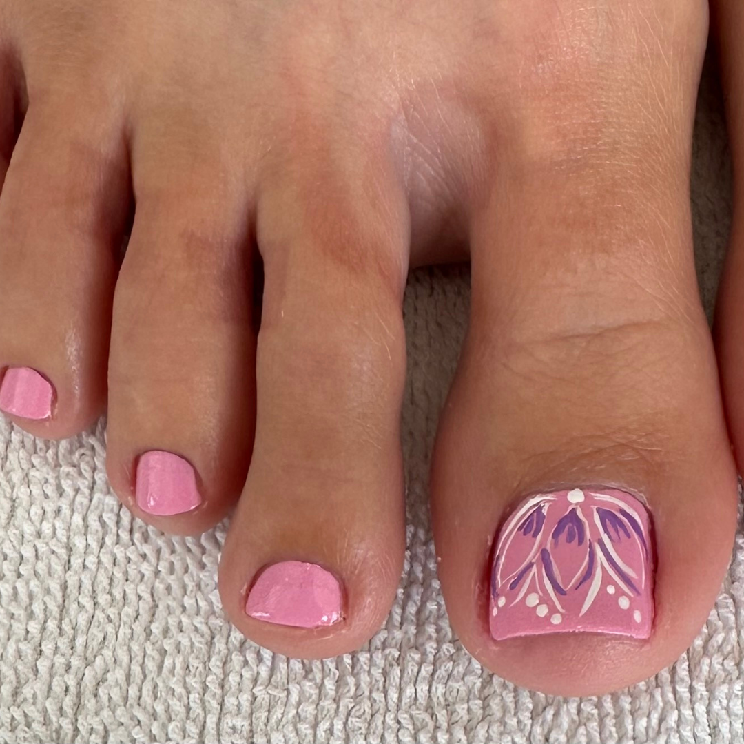 Elegant pink pedicure featuring intricate floral nail art on the big toe, perfect for a sophisticated and feminine touch. Available through our pedicure services at Casa D'Blanca Nails + Spa in Grimsby on the Lake.